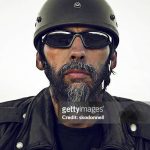 This is a portrait of a motorcycle biker on a grey background looking straight into the camera.There are similar images in the link below.